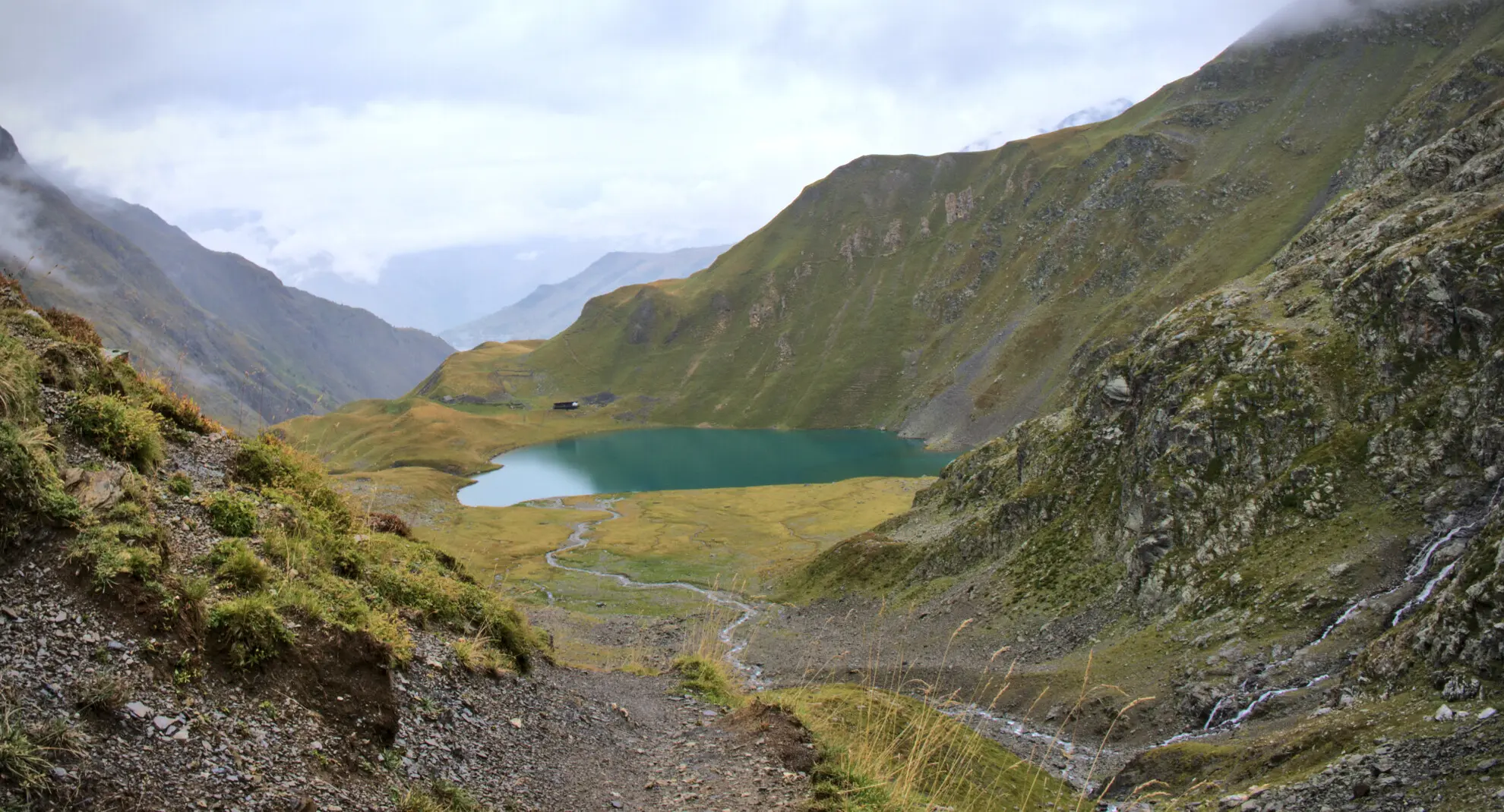 Lac de la Muzelle seen from the descent path, with the refuge at the water's edge