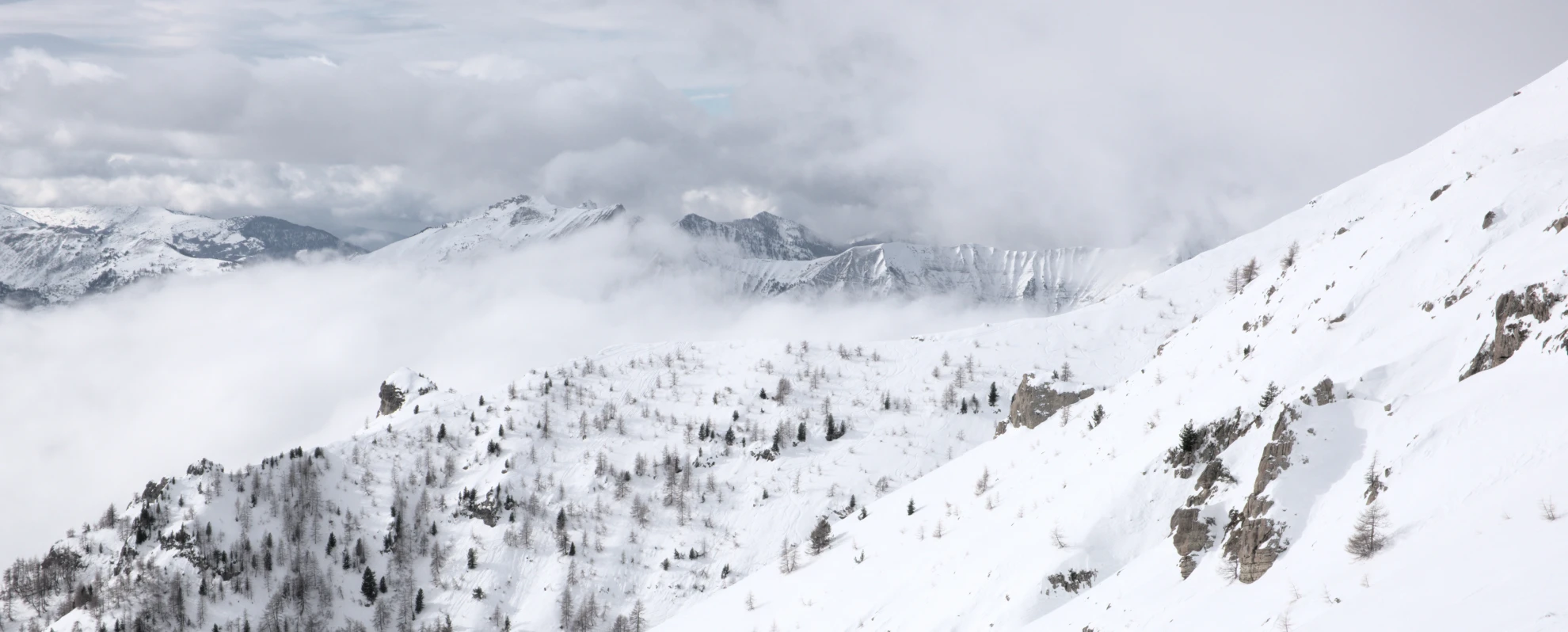 Snow-covered flank of Vieux Chaillol above a sea of cloud